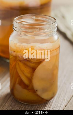 Kombucha de thé noir fait maison ou champignon de thé dans un pot en verre avec beaucoup de scoby, une boisson probiotique fermentée saine, sur une table en bois (Focus sélectif) Banque D'Images