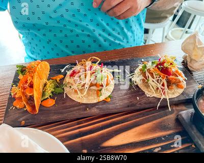 Trois tacos gourmands sur plateau en bois Banque D'Images