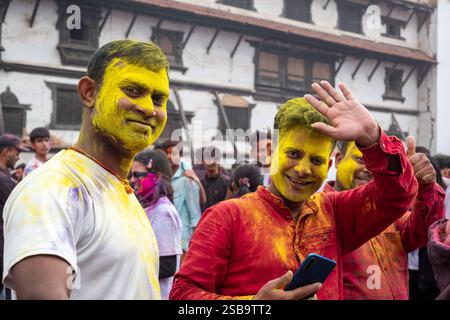 Deux hommes népalais souriants agitant le visage couvert de jaune pendant les célébrations Holi à Katmandou, au Népal Banque D'Images