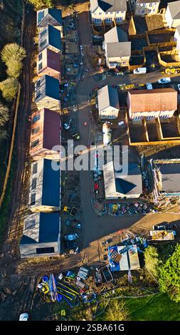 Vue aérienne d'un chantier de construction résidentielle. Plusieurs maisons à divers stades d'achèvement, ainsi que l'équipement et les matériaux de construction, sont Banque D'Images