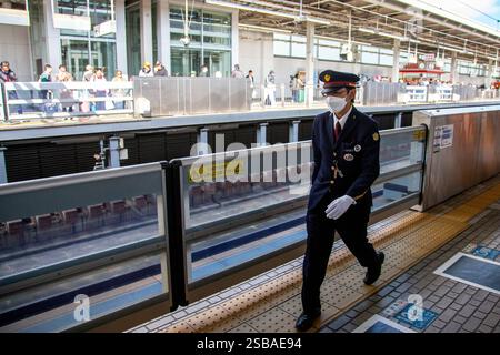 OSAKA, JAPON : le personnel du train Shinkansen marche sur un quai à la gare de Shin-Osaka. Banque D'Images