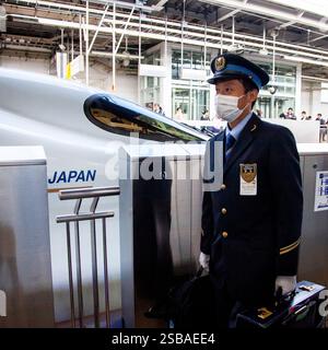 Un ingénieur train passant devant un train à grande vitesse Shinkansen N700 à la gare de Shin-Osaka. Banque D'Images