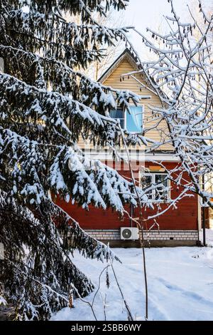 vew de petite maison rurale en bois de la cour enneigée le jour d'hiver Banque D'Images