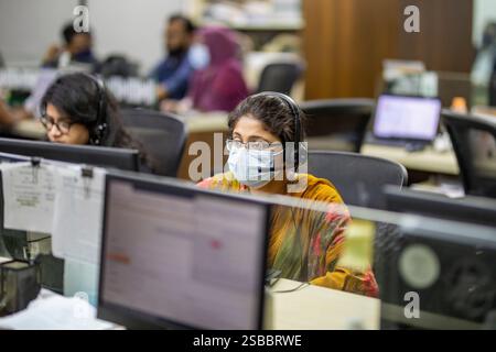 Des médecins bangladais offrent des consultations médicales à distance aux patients atteints de COVID-19 via un centre de télésanté, garantissant ainsi l’accès aux soins de santé pour les personnes touchées Banque D'Images