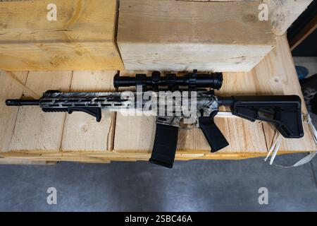 Un fusil de tireur tactique avec une vue optique repose sur des palettes en bois. Banque D'Images