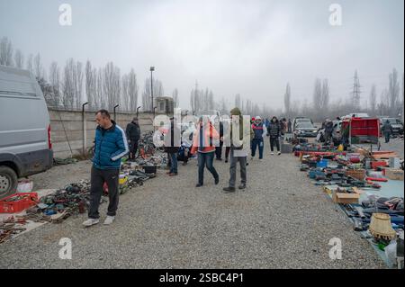 Hunedoara, Roumanie - 25 janvier 2025 : foule de gens et divers objets, jouets, outils et appareils électroniques à un marché aux puces. Banque D'Images