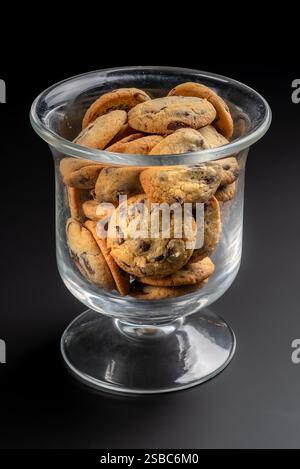 Biscuits au chocolat dans un pot en verre transparent sur fond noir Banque D'Images