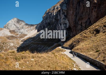 Famille profitant d'une randonnée tranquille le long d'une route de montagne sinueuse au milieu du paysage magnifique. Mont Mangart, Slovénie Banque D'Images