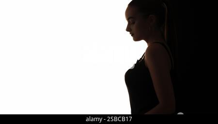 Silhouette féminine. Beauté paisible. Contour de profil sombre de la femme tendre calme tranquille isolée sur fond d'espace de copie blanc. Banque D'Images