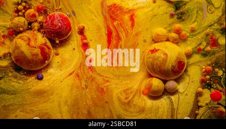 Taches de peinture. Bulle éclatée. Gouttes colorées particules se répandant dans l'eau. Pigment étincelant jaune rouge huile explosant fond abstrait. Banque D'Images
