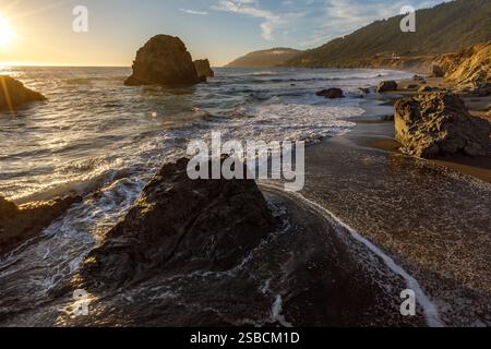 Coucher de soleil sur la plage de la côte rocheuse Banque D'Images