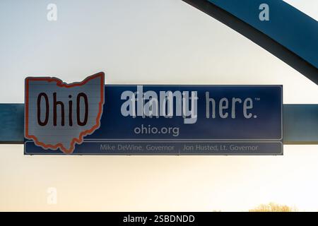 Cedar Springs, États-Unis - 3 novembre 2022 : lever du soleil dans le Midwest Ohio signe sur l'autoroute 70 frontière texte de bienvenue pour trouver ici slogan contre le ciel Banque D'Images