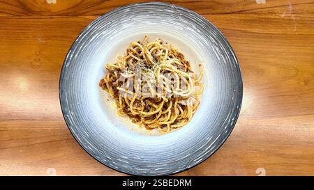 Délicieuses spaghetti carbonara italiennes servies dans une assiette avec du fromage râpé et des herbes, mettant en valeur un plat de pâtes classique adapté à la photographie culinaire, m Banque D'Images