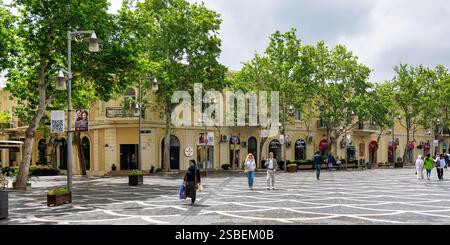 Bakou, Azerbaïdjan - 5 mai 2024 : promenez-vous tranquillement dans la rue Nizami, où les charmantes boutiques et les arbres luxuriants offrent une ambiance sereine au milieu d'un ciel couvert de nuages, favorisant une atmosphère urbaine dynamique Banque D'Images