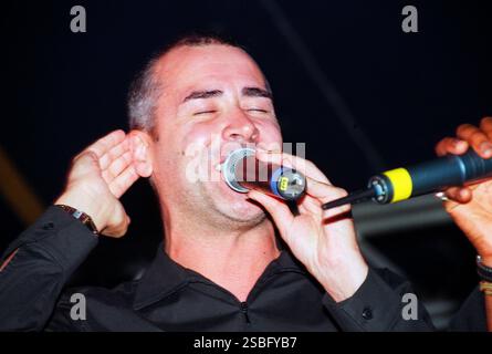 PHIL OAKEY, READING FESTIVAL, 1999 : Phil Oakey de la Human League chantant en tant qu'artiste invité avec le groupe The All Seeing I au Reading Festival, Reading, Royaume-Uni, le 28 août 1999. Photo : Rob Watkins. INFO : The All Seeing I, un groupe britannique de musique électronique, a émergé dans les années 90 avec leur son éclectique mêlant danse, pop et éléments expérimentaux. Des tubes comme « Beat Goes on » ont mis en avant leur approche innovante, ce qui leur a valu d'être reconnus comme pionniers de la scène musicale électronique britannique. Banque D'Images