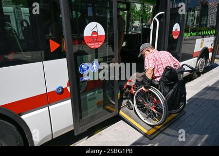 Lyon (centre-est de la France) : usagers handicapés et accessibilité aux transports en commun. Personne âgée en fauteuil roulant embarquant dans un bus équipé d'un acce Banque D'Images