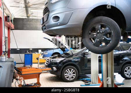 Voitures entretenues dans un atelier de réparation automobile professionnel, présentant le processus d'entretien automobile Banque D'Images
