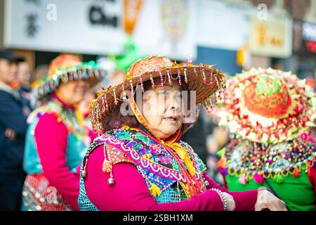 Vieille dame asiatique senior en robe traditionnelle et chapeau à la parade du nouvel an chinois CNY 2025 à Newcastle upon tyne, royaume-uni - année du serpent Banque D'Images