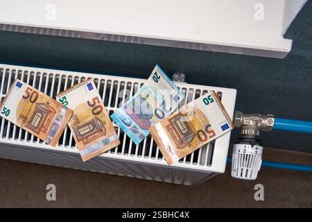 Bavière, Allemagne - 1er février 2025 : billets en euros posés sur un radiateur. Image symbolique de l'augmentation des coûts de chauffage, des coûts élevés de l'énergie et de la charge financière des factures d'électricité *** Euro-Geldscheine liegen auf einem Heizkörper. Symbolbild für steigende Heizkosten, hohe Energiekosten und die finanzielle Belastung durch Nebenkostenabrechnungen Banque D'Images