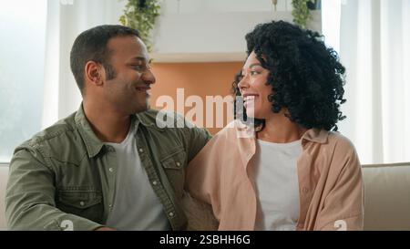 Heureux parents afro-américain mère père embrasser câlin sur canapé couple mari épouse affectueuse mariée fille gars souriant homme femme anniversaire Banque D'Images