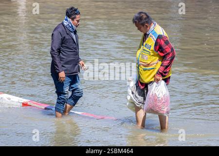 SAMUT PRAKAN, THAÏLANDE, 19 nov 2024, Un homme patate dans une rue inondée Banque D'Images