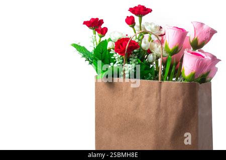 Un bouquet coloré de fleurs artificielles, y compris des fleurs roses, rouges et blanches dans un sac en papier. parfait pour la décoration, cadeau ou displ romantique Banque D'Images