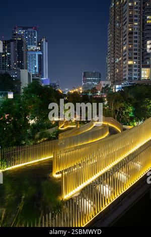 Vue sur le parc du canal Chong Nonsi vide et illuminé et les gratte-ciels hauts dans le district de Khlong Chong Nonsi à Bangkok, Thaïlande au crépuscule. Banque D'Images