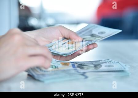 Trader femme mains comptant des dollars américains sur la table. Concept de réussite, d'entreprise et d'idée financière. Gros plan Banque D'Images