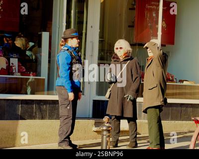 Agent de soutien communautaire de la police (PCSO) en uniforme chargé de répondre aux demandes de renseignements de deux membres plus âgés du public dans le centre-ville de Bath, Bath Somerset. Banque D'Images