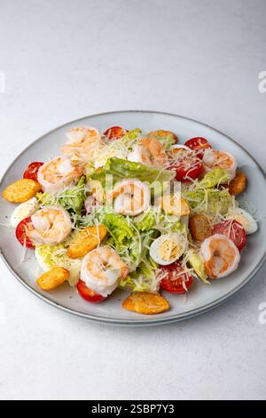 Salade César avec crevettes tigrées, tomates cerises, croûtons, parmesan, œufs de caille et laitue romaine. Plat traditionnel américain. Gros plan, selec Banque D'Images
