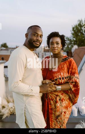Portrait d'un couple nouvellement marié dans des vêtements traditionnels debout sur le toit Banque D'Images