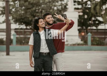 Deux amis masculins prenant un selfie dans la rue. Portrait d'amis drôles prenant un selfie dans la rue Banque D'Images