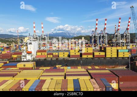 Vue en angle élevé de conteneurs d'expédition de boîtes métalliques rectangulaires empilés sur le quai en attente d'être chargés sur le navire de charge MSC Renaissance III à la Spezia c Banque D'Images