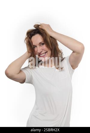 Heureuse femme mature riant debout isolé sur fond blanc. Souriant confiant gai d'âge moyen dame des années 50 avec le sourire blanc dentaire regardant Banque D'Images