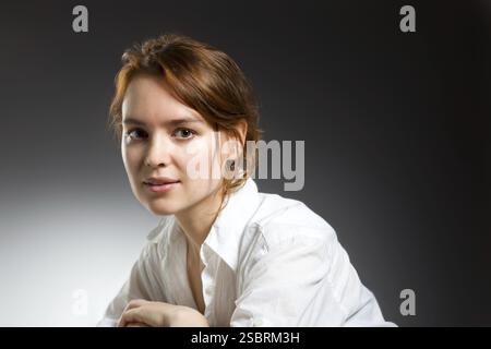Portrait de mode beauté. Belle jeune femme sur fond de mur gris Banque D'Images