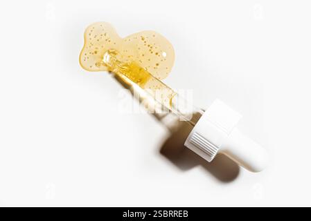 Pipette de sérum rétinol face isolée sur fond blanc gros plan. Échantillon de produit cosmétique collagène pour le visage dans un compte-gouttes en verre. Banque D'Images