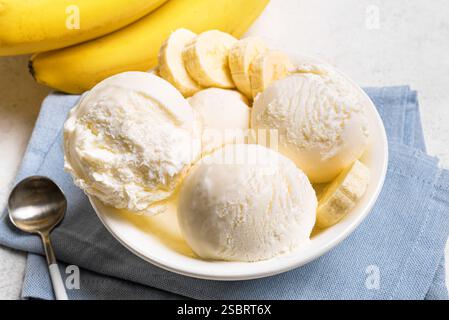 Cuillères à crème glacée et morceaux de banane dans un bol gros plan. Crème glacée saine banane crue végétalienne (nicecream) servie dans un bol, dessert bio maison, laiterie fr Banque D'Images