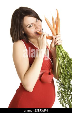 21 semaines femme enceinte heureuse avec des carottes fraîches Banque D'Images