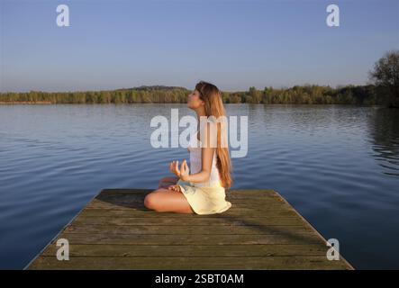Belle jeune femme faisant du yoga de l'exercice à l'extérieur Banque D'Images