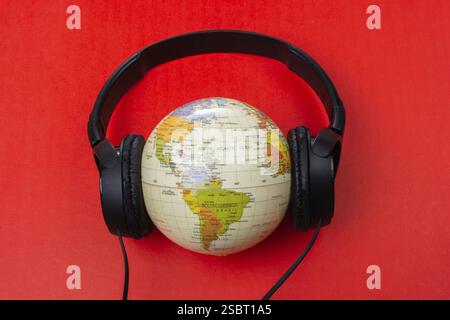Micro-casque sur globe isolé sur le rouge Banque D'Images
