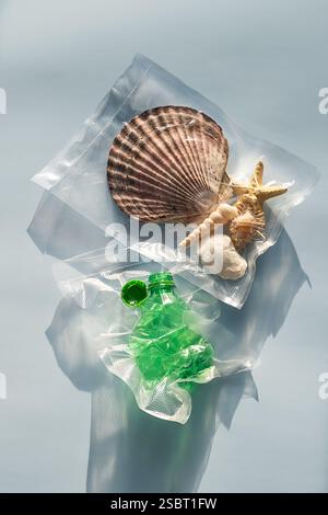 Emballage scellé sous vide pour coquilles marines et bouteilles en plastique. Nature vs concept de déchets plastiques. Banque D'Images