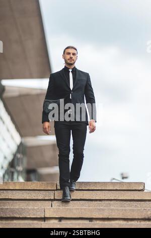 Beau jeune homme d'affaires élégant posant portrait en plein air Banque D'Images