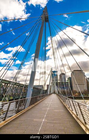 Marcher sur l'un des ponts du Jubilé d'Or à Londres, nommé en l'honneur du Jubilé d'Or d'Elizabeth II. le pont piétonnier à haubans... Banque D'Images