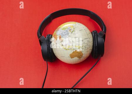 Micro-casque sur globe isolé sur le rouge Banque D'Images