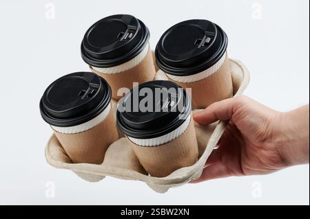 Plateau de maintien à la main avec tasses en papier pour le café isolé sur fond blanc de studio Banque D'Images