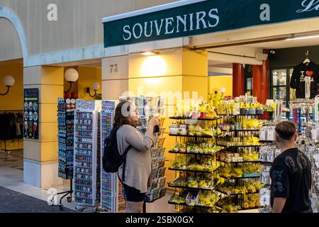 Sirmione, Italie - Sep 21st, 2024 : une femme parcourant des cartes postales et des souvenirs dans une boutique de cadeaux dans le centre historique de Sirmione Banque D'Images