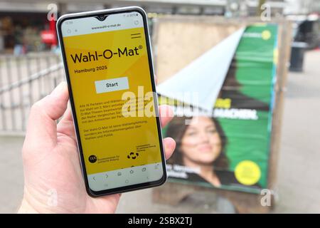 Ein Mann hält vor einem Wahlplakat der Partei Die Grünen/Bündnis 90 ein smartphone in der hand, auf dem der Wahl-O-Mat zur Bürgerschaftswahl in Hamburg geöffnet ist. Eppendorf Hambourg *** Un homme tient un smartphone devant une affiche électorale pour le Parti Vert Bündnis 90, sur laquelle le Wahl O Mat pour les élections législatives à Hambourg est ouvert Eppendorf Hambourg Banque D'Images