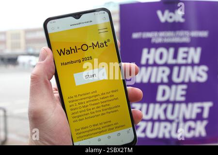 Ein Mann hält vor einem Wahlplakat der Partei Volt ein smartphone in der hand, auf dem der Wahl-O-Mat zur Bürgerschaftswahl in Hamburg geöffnet ist. Eppendorf Hambourg *** Un homme tient un smartphone devant une affiche électorale du parti Volt, sur laquelle le Wahl O Mat pour les élections législatives de Hambourg est ouvert Eppendorf Hambourg Banque D'Images