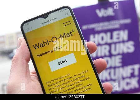 Ein Mann hält vor einem Wahlplakat der Partei Volt ein smartphone in der hand, auf dem der Wahl-O-Mat zur Bürgerschaftswahl in Hamburg geöffnet ist. Eppendorf Hambourg *** Un homme tient un smartphone devant une affiche électorale du parti Volt, sur laquelle le Wahl O Mat pour les élections législatives de Hambourg est ouvert Eppendorf Hambourg Banque D'Images