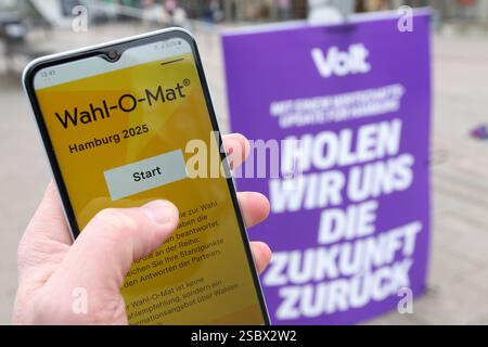 Ein Mann hält vor einem Wahlplakat der Partei Volt ein smartphone in der hand, auf dem der Wahl-O-Mat zur Bürgerschaftswahl in Hamburg geöffnet ist. Eppendorf Hambourg *** Un homme tient un smartphone devant une affiche électorale du parti Volt, sur laquelle le Wahl O Mat pour les élections législatives de Hambourg est ouvert Eppendorf Hambourg Banque D'Images